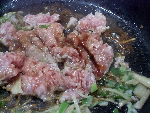 肉と香味野菜を炒める