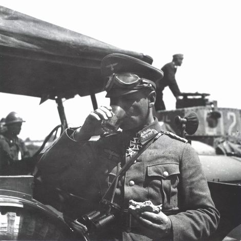 Erwin Rommel having a drink and quick snack in the side of vehicle
